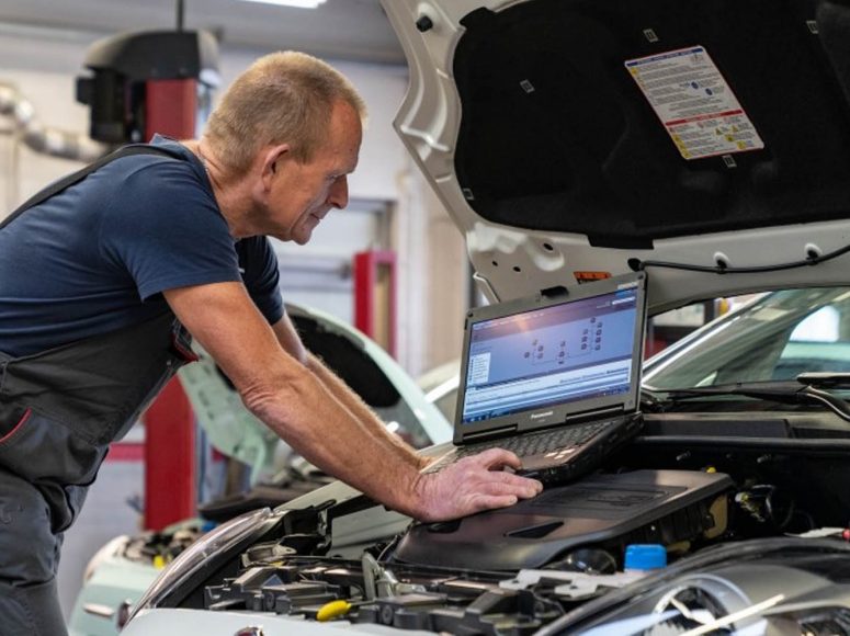 Mechaniker von Autohaus Beier TOP Markenspezialist für Peugeot , Citroën führt eine HU/AU an einem Auto durch.