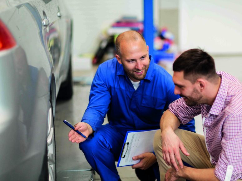 Mechaniker und Kunden besprechen Herstellergarantie beibehalten bei TOP Markenspezialist Autohaus Beier. Spezialist für Peugeot , Citroën